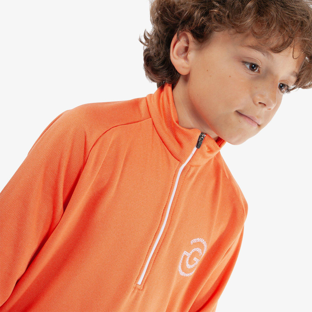 Raz is a Insulating golf mid layer for Juniors in the color Orange(3)